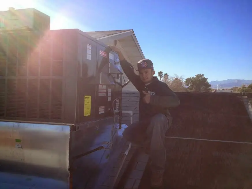 HVAC technician performing Air Duct Cleaning on a rooftop unit in Woodway