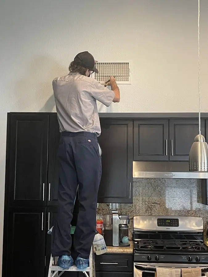 Technician inspecting an air vent during HVAC service in Woodway